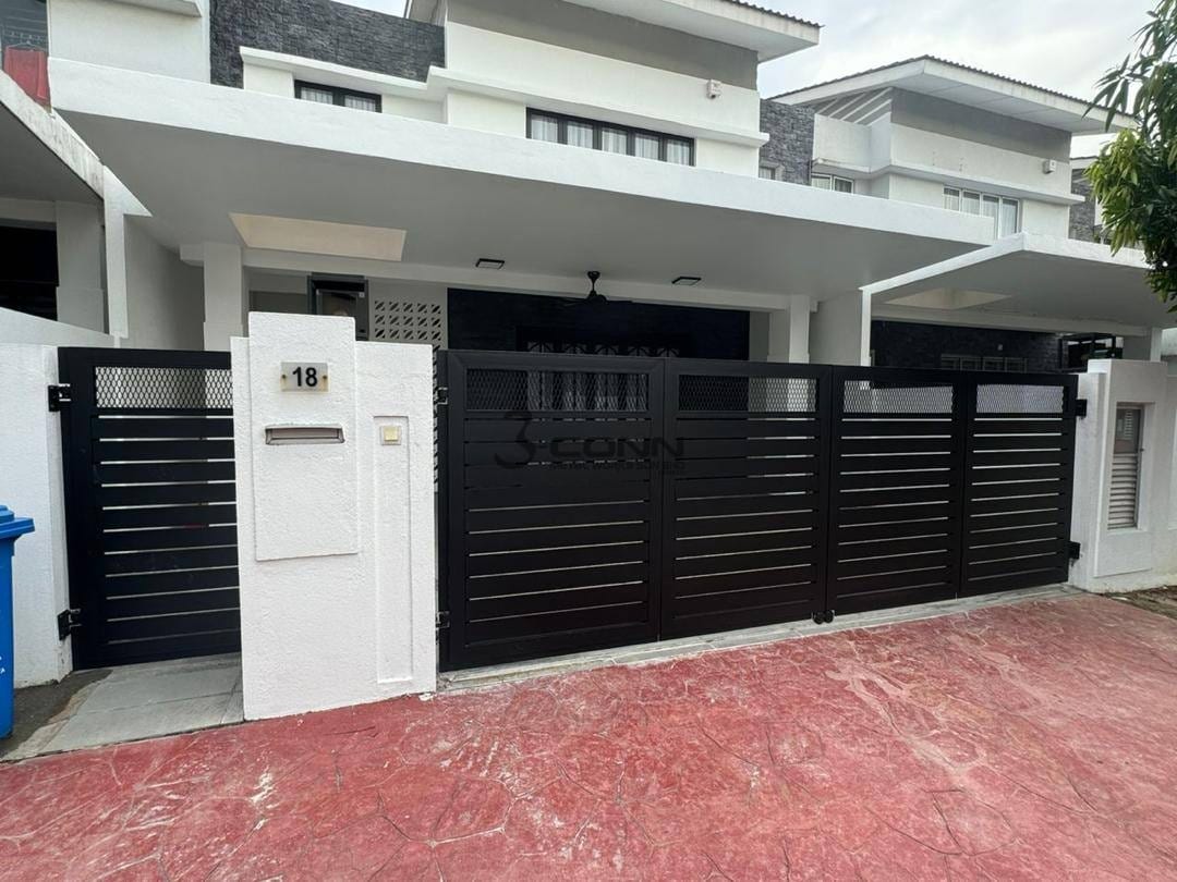 A black mild steel main gate with vertical bars across the driveway of a double-storey house.