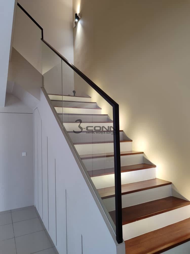 A timber wall handrail with a slim black bar railing on the open side of a flight.